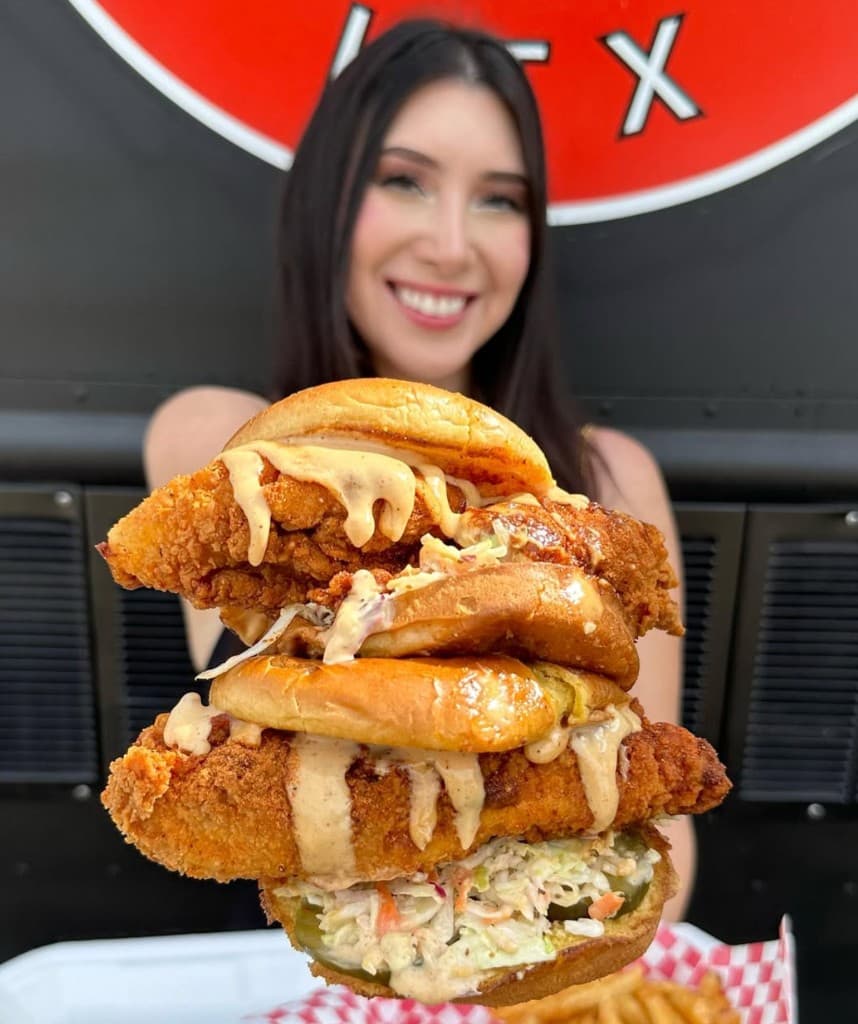 Guest holding Birdside hot chicken in front of the Katy truck.